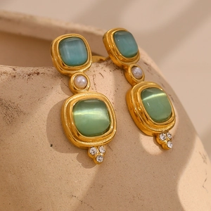 Détail de boucles d'oreilles vintage en or 18K avec œil de chat vert, perle et diamants