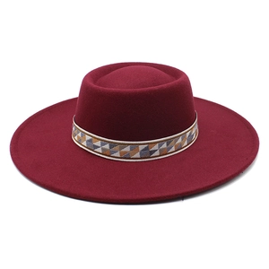 Detail of the flat crown and ethnic geometric ribbon on the burgundy wool felt hat