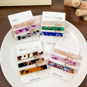 Three-piece acetate hair clip set with marble patterns displayed on an elegant white plate