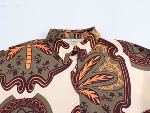 Detail of bohemian resort style shirt featuring tropical palm tree print and size S label