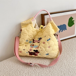 Detail of cartoon puppy embroidery and nice lettering on yellow quilted tote bag