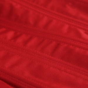 Vue macro détaillée des coutures parallèles sur le tissu rouge vif du corset
