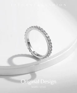 Macro shot of silver eternity band with moissanite diamonds on minimalist white base