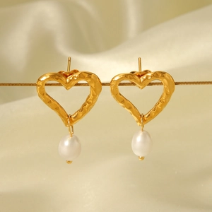 Détail de boucles d'oreilles cœur martelé doré avec perles blanches sur soie