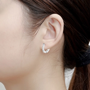 Model wearing a 9mm silver stainless steel huggie hoop earring with white cubic zirconia