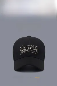 Close-up of embroidered letters on black baseball cap showing detailed twill texture