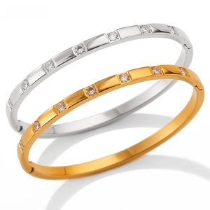 Macro detail of gold and silver bangles featuring inlaid round clear cubic zirconia