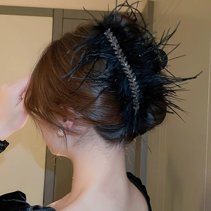 Elegant black feather hair claw clip with rhinestones worn on hair side view