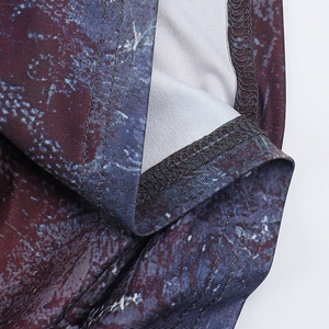 Gros plan sur la double couture et le motif marbré abstrait sur l'ourlet de la robe