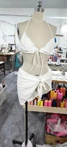 Detail showing white pleated texture on halter bikini top and matching sarong set