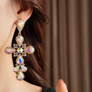 Detail of vintage cross earring with rainbow crystals and rhinestones on model
