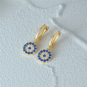 Detail von s925 Gold Evil Eye Creolen mit blauen und weißen Kristallen auf Stein