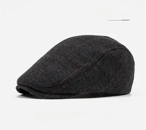 Detail shot of a dark grey tweed flat cap with herringbone pattern and red windowpane check