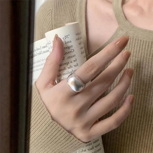Minimalist wide arc 925 silver ring with high polish finish worn by model as statement jewelry
