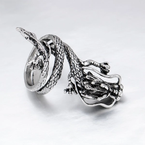 Macro shot of silver metal dragon ring with intricate scale texture and vintage finish