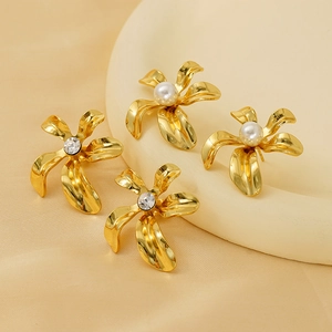 Macro view of gold flower stud earrings featuring pearl and rhinestone centers