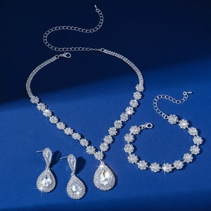 Detail of silver droplet jewelry set with white rhinestones on dark blue background