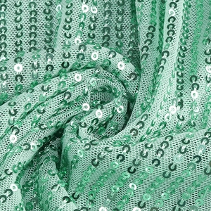 Close-up of mint green sequins on mesh fabric showing texture for a fishtail gown