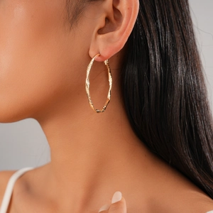 Minimalist twisted geometric golden hoop earrings for women with textured metal finish