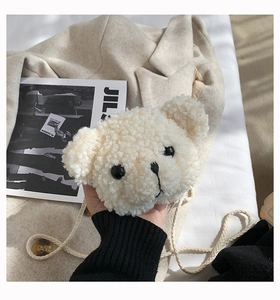 Detail of soft cream teddy plush fabric and cute bear facial embroidery on the crossbody bag