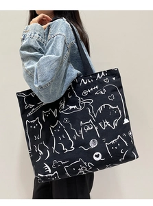 Close-up of black canvas tote bag with white cat doodle print and Mi Mi lettering