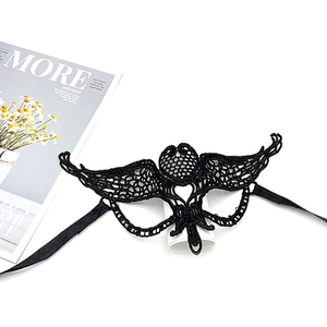 Detail of elegant black lace masquerade mask with intricate cutout patterns and silk ribbons