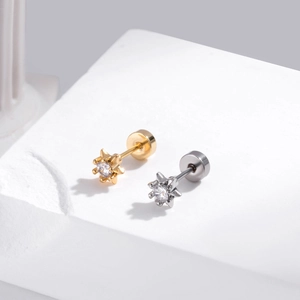 Gros plan de boucles d'oreilles étoile en or et argent avec zircon sur socle blanc
