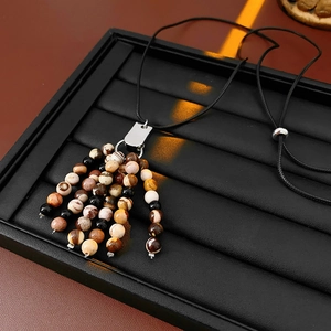 Close-up of vintage natural stone beaded fringe pendant with adjustable black cord
