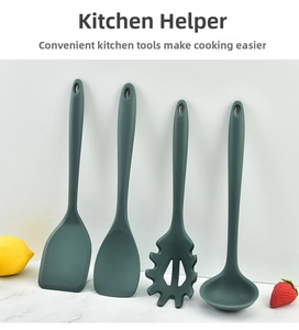 Detailed view of four-piece dark green silicone kitchen utensil set on marble surface