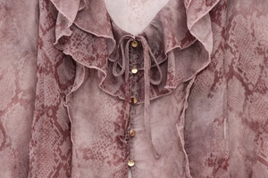 Detail of V-neckline with ruffle layers, gold buttons and snake print on chiffon top