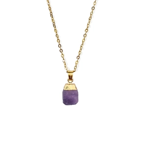 Macro detail of natural faceted purple stone pendant with gold plating and fine chain