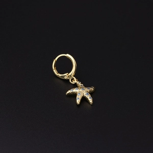 Detail of gold starfish hoop earring featuring textured metal and blue zircon stones