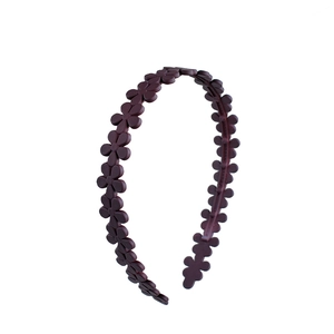 Detail of burgundy matte flower headband with non-slip teeth for secure styling