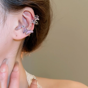 Detailed view of gold ear cuff featuring purple zircon butterflies on a female ear