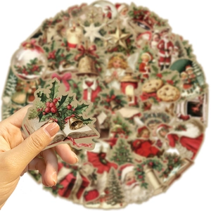 Close-up of vintage Christmas stickers featuring Santa and holly on a laptop cover