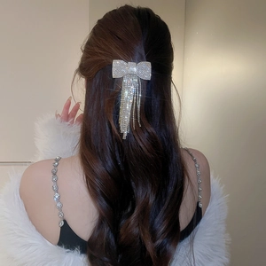 Détail d'une pince à cheveux nœud en strass étincelants avec de longues franges élégantes