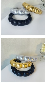 Three padded PU leather headbands in black, silver and gold finish on white background