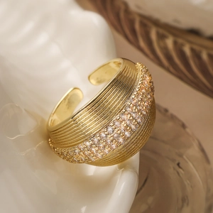 Luxurious 18K gold plated textured ring with sparkling cubic zirconia on white ceramic tray