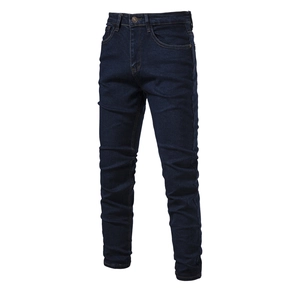 Detailed close-up of dark blue slim fit denim jeans showing washed twill texture and waist