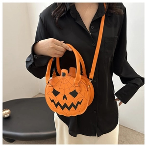 Detail of creative orange pumpkin shoulder bag with spooky face print and adjustable strap