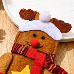 Close-up of a gingerbread reindeer felt cutlery holder on a rustic wooden table