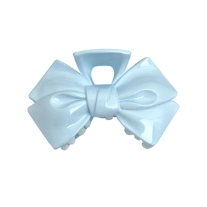 Light blue bow-shaped hair claw clip with glossy star details on a clean white background