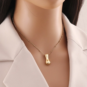 Dettaglio della collana con pendente a goccia placcata oro 18K con catena a sfere su modella