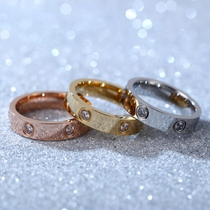 Macro shot of stainless steel screw motif rings with crystals in gold, silver, and rose gold