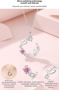 Macro shot of silver crescent moon necklace featuring pink cubic zirconia and polished finish