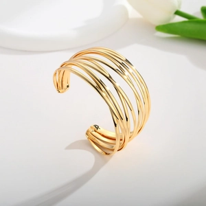 Detail of 18K gold multilayer open cuff bracelet styled with white tulip decor