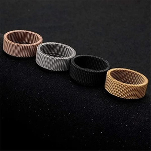 Detail of mesh woven texture rings in bronze, silver, black, and gold titanium steel