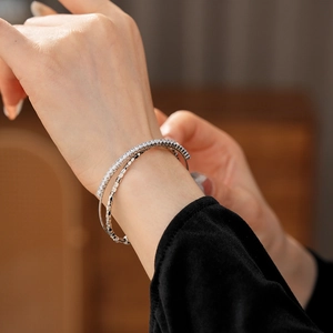 Detailed close-up of a silver double-layer bracelet with cubic zirconia and beads