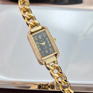 Detail of square gold quartz watch with diamond bezel and trendy thick chain bracelet