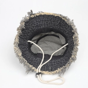 Detail view of denim bucket hat featuring adjustable drawstring and frayed edges